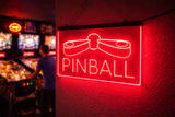 Neon sign on a wall with 'Pinball' text in a pinball machine arcade setting