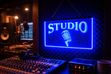 Studio sign with microphone graphic on a sound mixing console