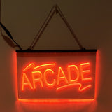 An LED sign with the word 'ARCADE' written in capital letters, glowing in red color, mounted on a wall with a visible power cord.